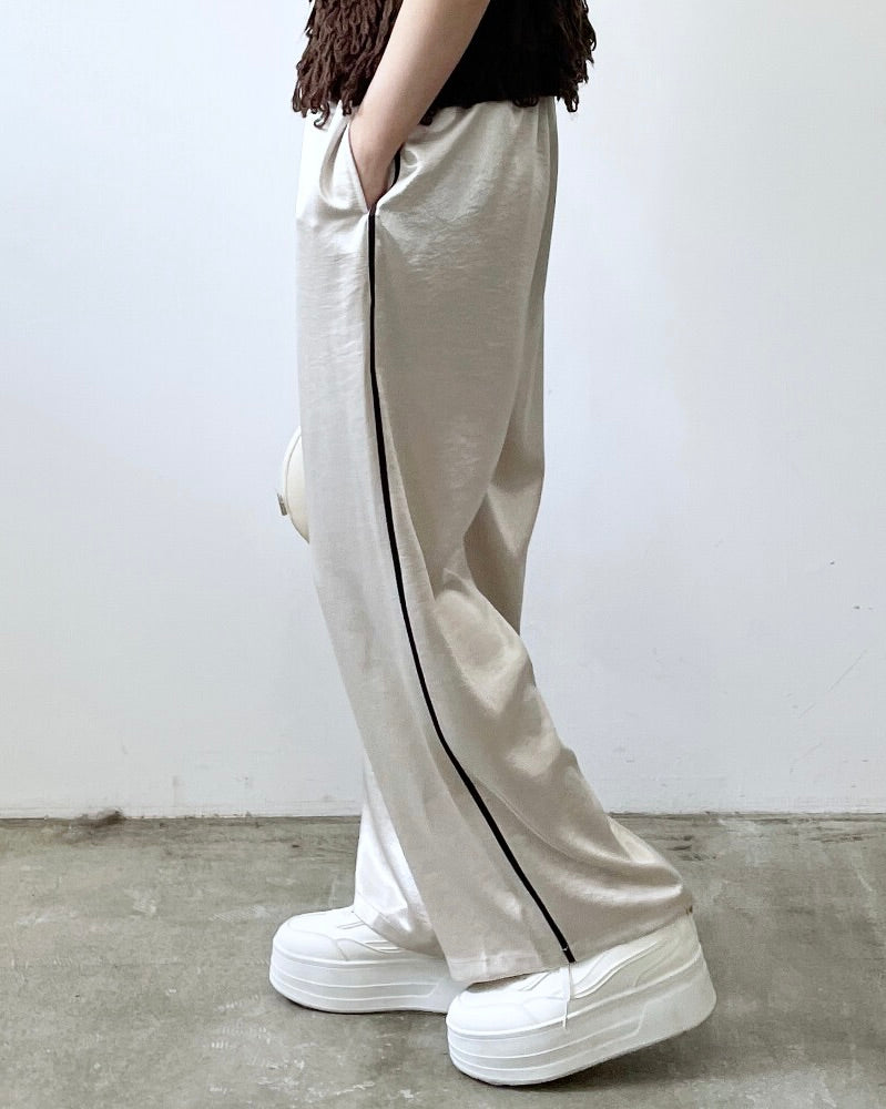 サテンサイドラインパンツ レディースの裾デザイン。 サイドラインが際立ち、パンプスやスニーカーとも相性の良いシルエットです。